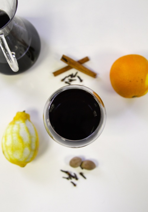 a beautiful image of mulled wine, lemon, orange, cinnamon and spices