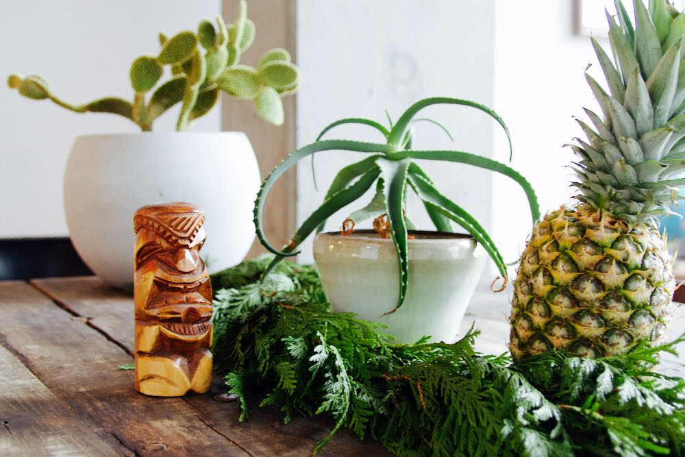tiki inspired holiday tablescape with green and white elements