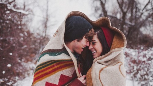 Christmas couple wrapped in vintage wool blanket