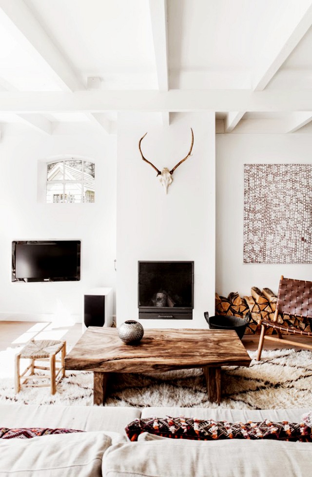 White room with antlers on the wall and rustic furniture