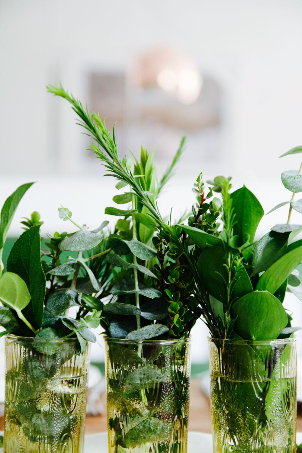 Simple centerpiece of greenery in vintage glasses