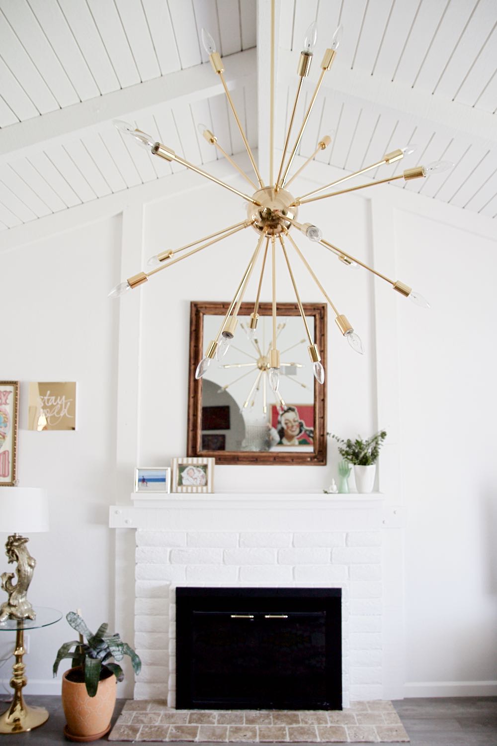 All white living room with exposed beams and sputnik chandelier
