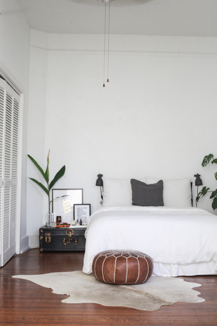 minimalist bedroom with low bed and plant