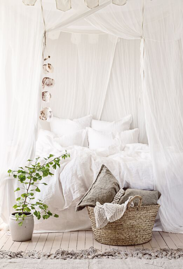 romantic white canopy bed with draped linen