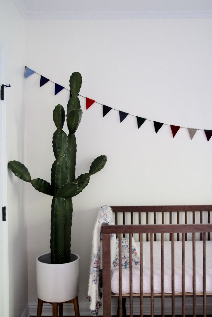 Clean and modern baby nursery with cactus and flags