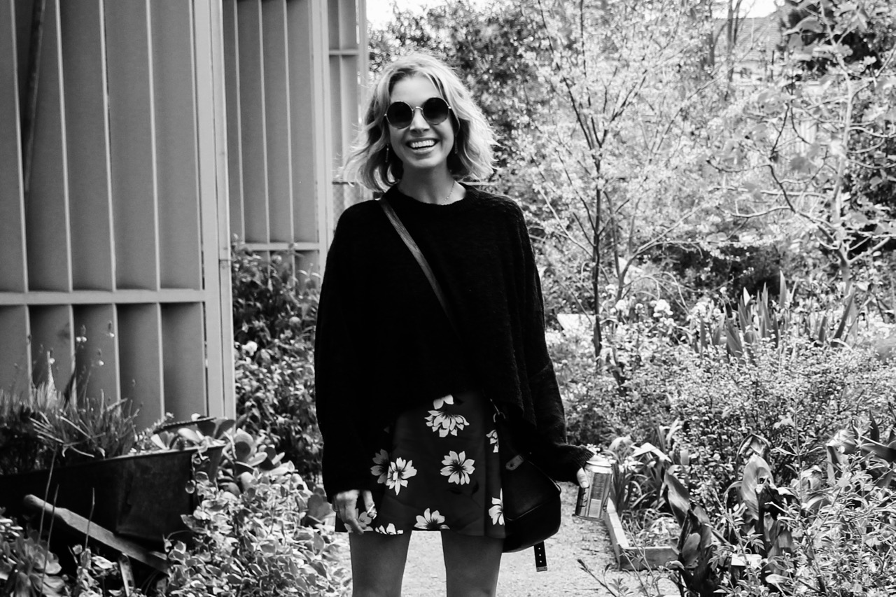 round sunglasses cropped black sweater and floral minidress
