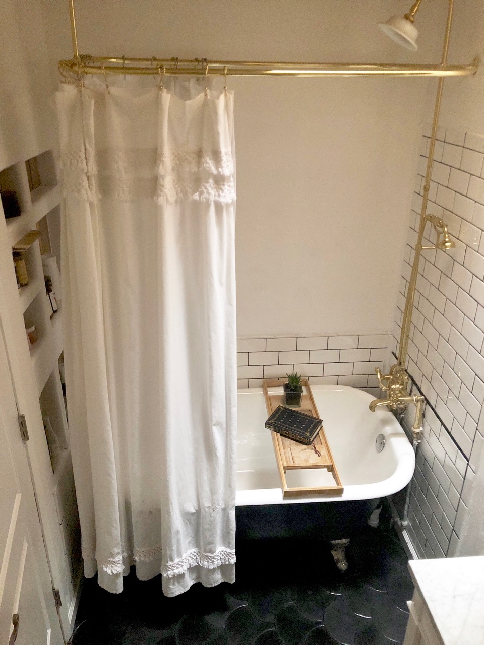 bathroom renovation with black clawfoot tub and gold fixtures